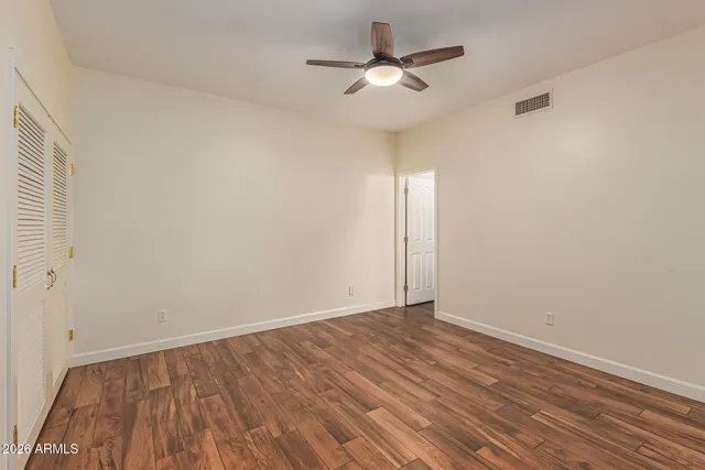 a view of an empty room with wooden floor
