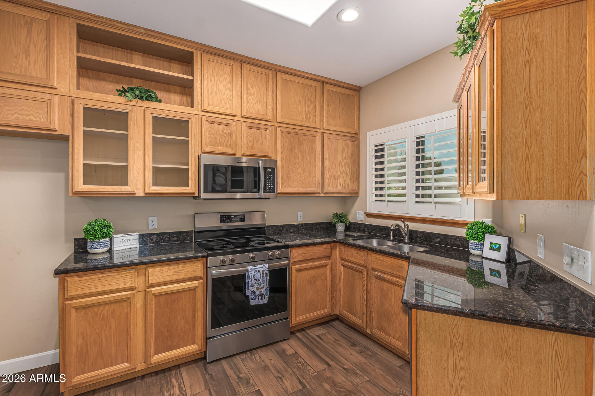 5445 East McKellips Road, Unit 25 Mesa, AZ 85215 - Photo 5 of 32 a kitchen with stainless steel appliances granite countertop a sink a stove and cabinets with wooden floor