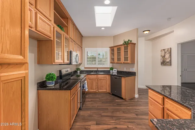 a kitchen with granite countertop a sink and stove top oven