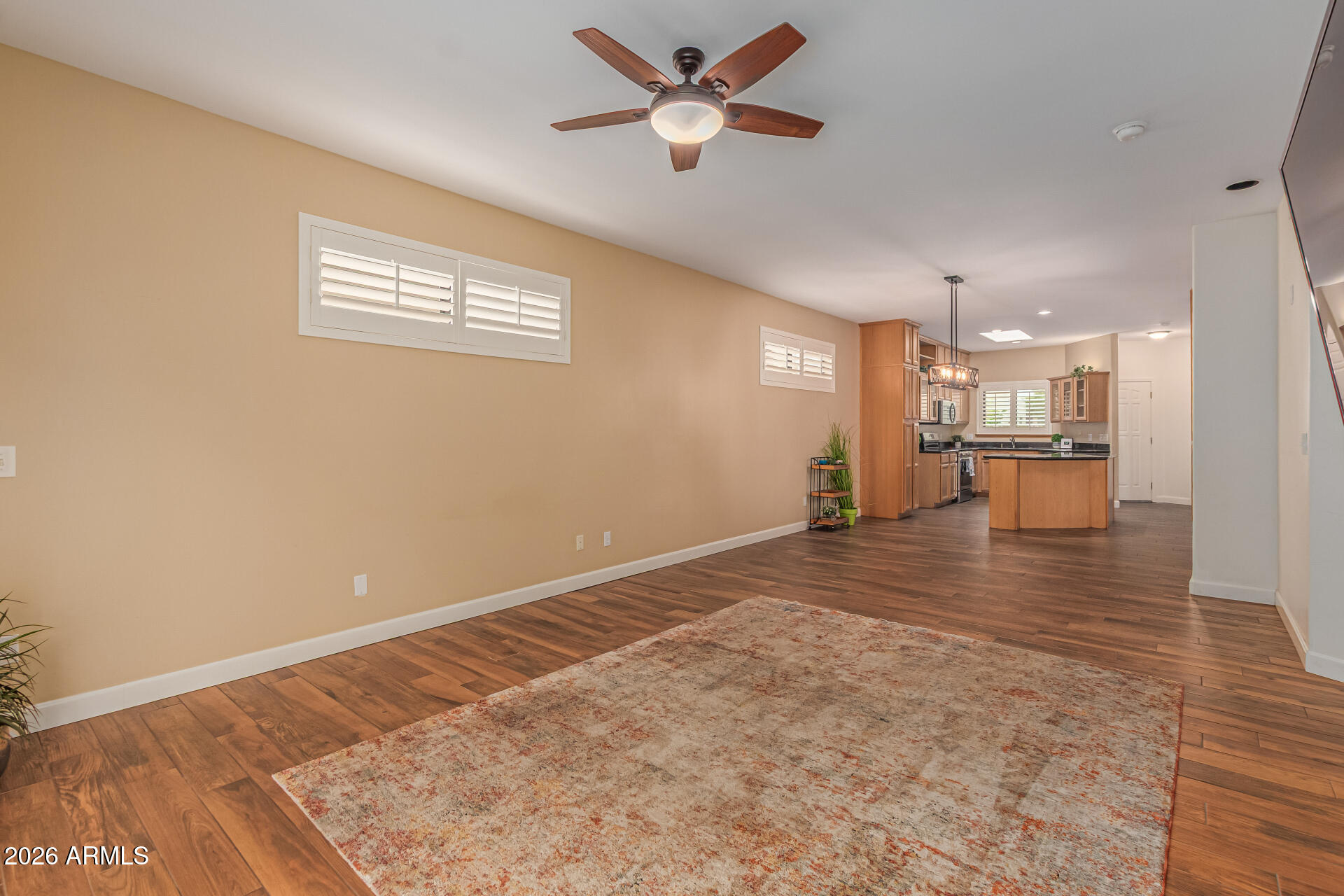 5445 East McKellips Road, Unit 25 Mesa, AZ 85215 - Photo 10 of 32 an empty room with wooden floor and a ceiling fan