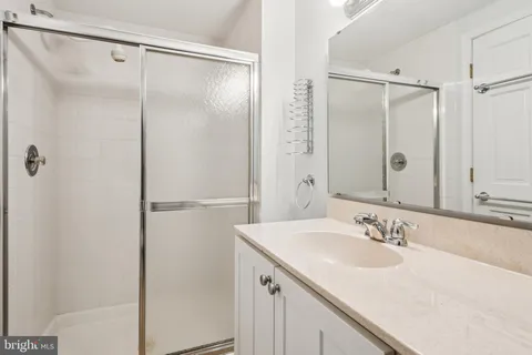 a bathroom with a shower sink and mirror