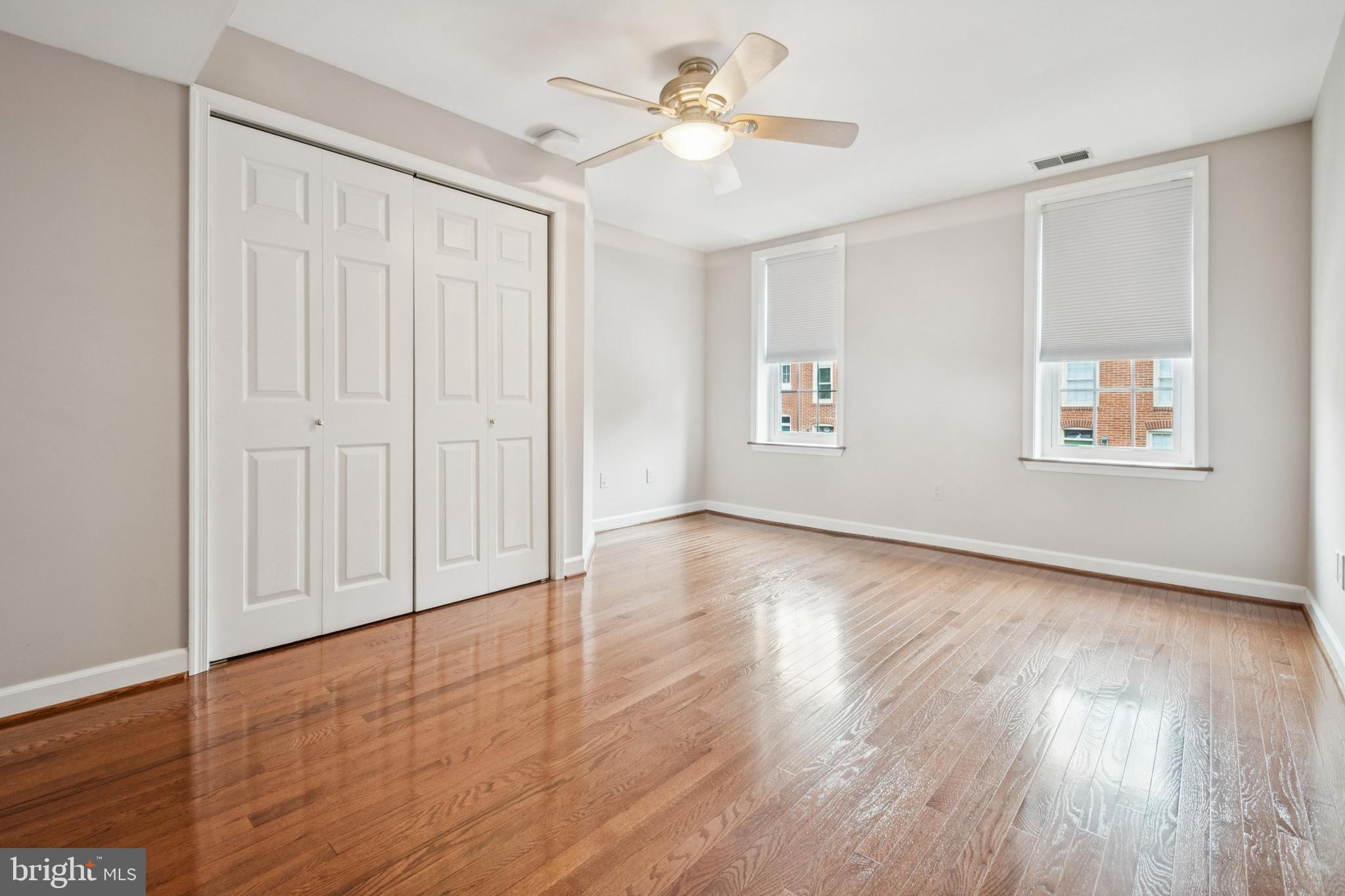 1134 Battery Avenue Baltimore, MD 21230 - Photo 17 of 30 an empty room with wooden floor chandelier fan and windows