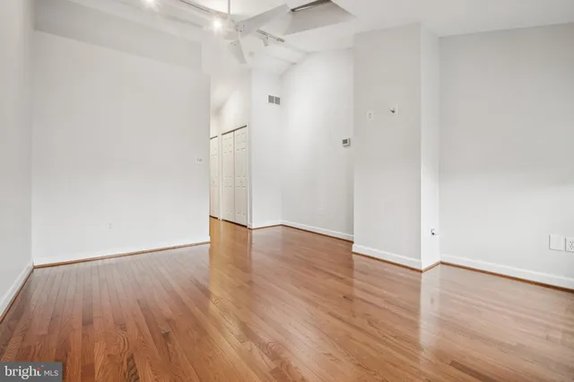 a view of an empty room with wooden floor
