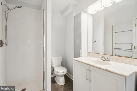 a bathroom with a granite countertop sink toilet and shower