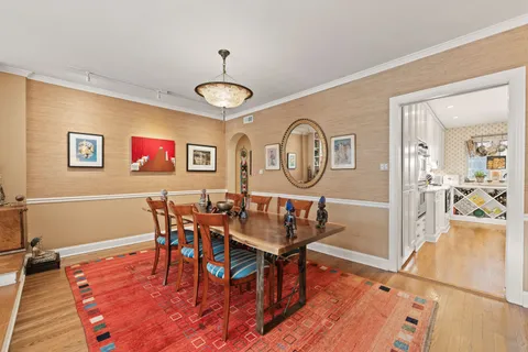 a view of a dining room with furniture a chandelier and wooden floor