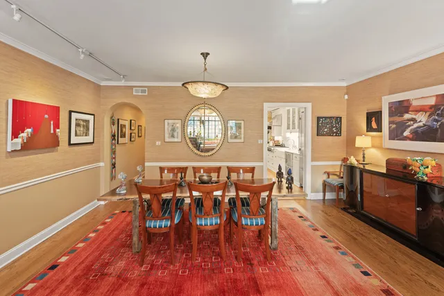 a view of a dining room with furniture a chandelier and wooden floor