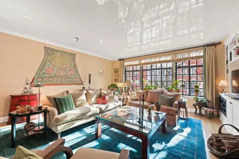 a living room with furniture a fireplace and a large window