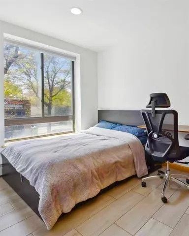 a bedroom with a bed and a flat tv screen next to a window