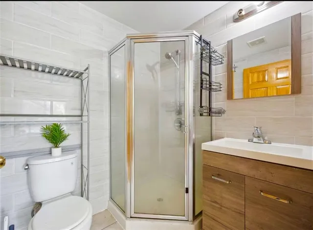 a bathroom with a granite countertop sink toilet and shower