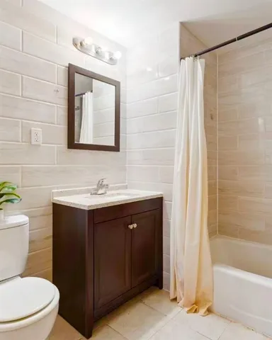 a bathroom with a toilet a sink a bathtub and a mirror