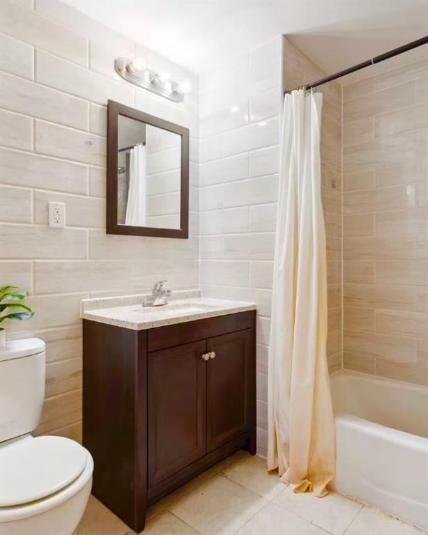 229 55th Street, Unit 2A Brooklyn, NY 11220 - Photo 10 of 12 a bathroom with a toilet a sink a bathtub and a mirror