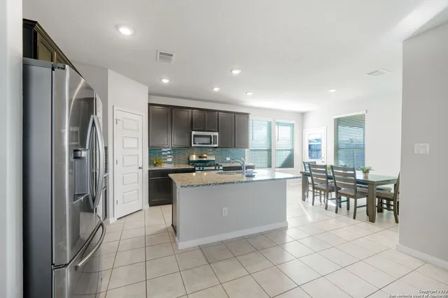 a kitchen with stainless steel appliances granite countertop a refrigerator and a stove top oven