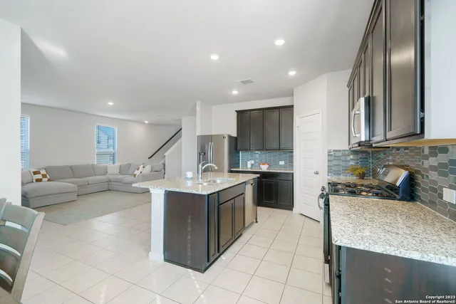 a kitchen with stainless steel appliances granite countertop a sink stove and cabinets