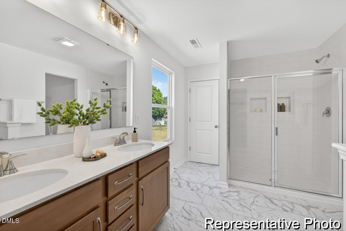 421 Plentiful Way, Unit 111 Benson, NC 27504 - Photo 15 of 27 a bathroom with a shower sink and mirror