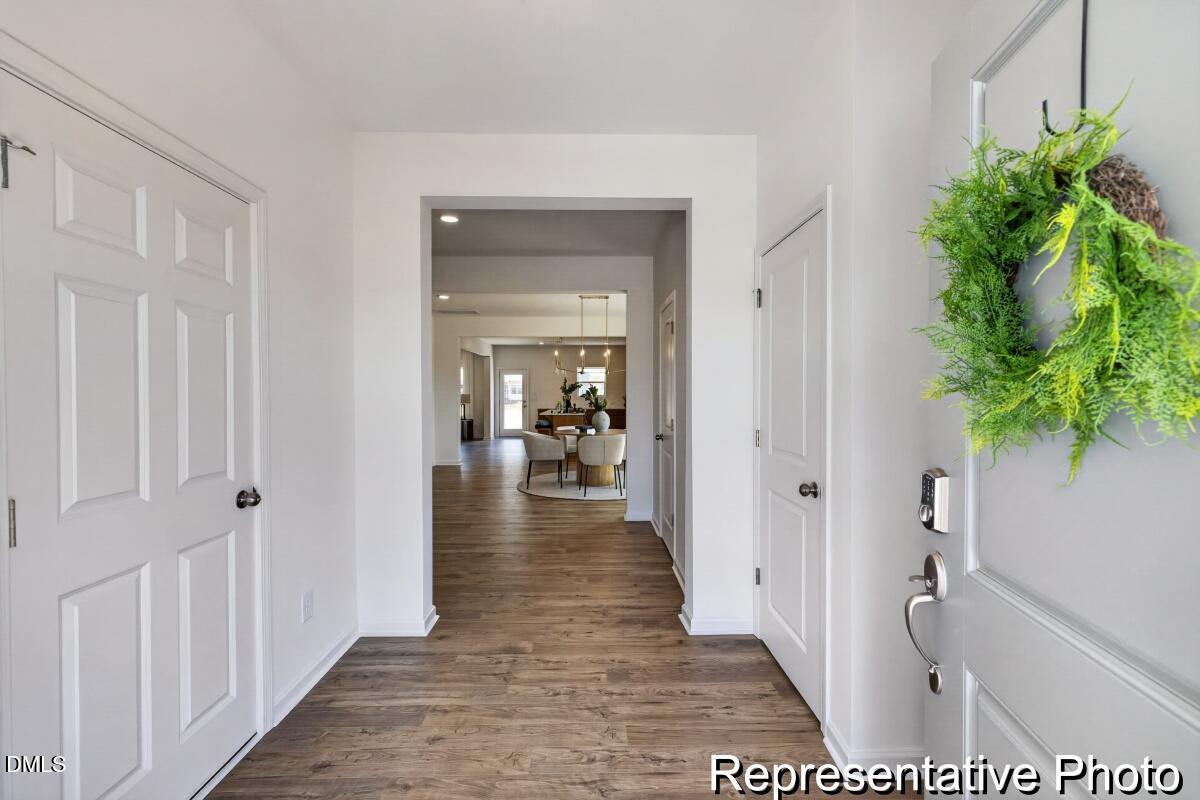 421 Plentiful Way, Unit 111 Benson, NC 27504 - Photo 25 of 27 a view of a hallway with wooden floor and a living room