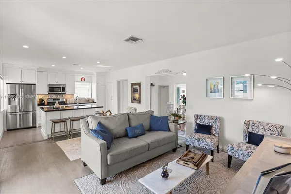 a living room with furniture kitchen and a table