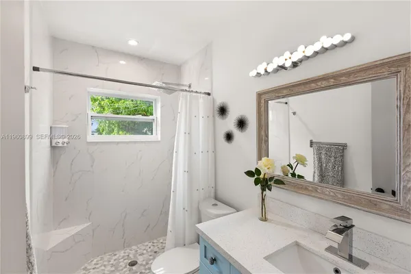 a bathroom with a sink toilet and shower