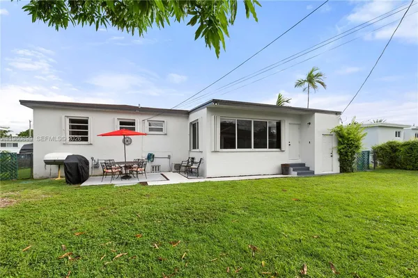 a view of a house with backyard and sitting area