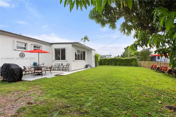 a backyard of a house with table and chairs