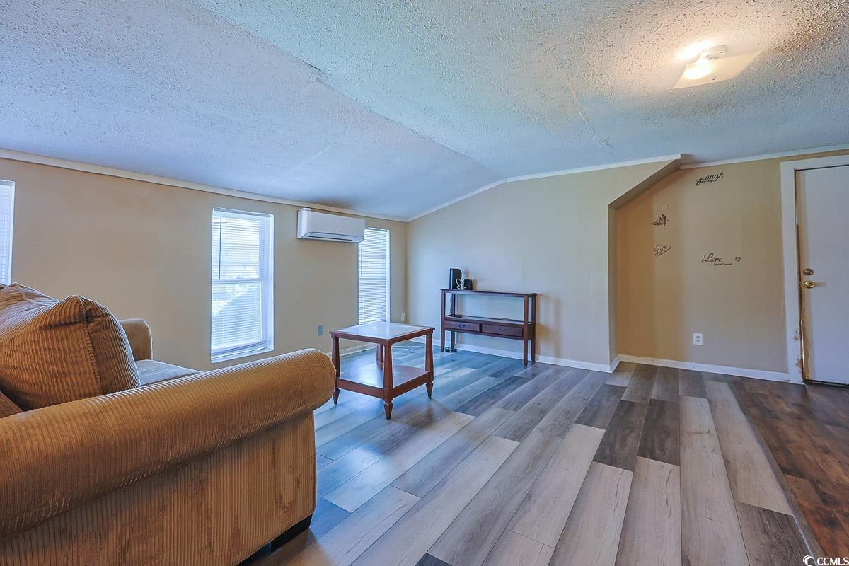 4300 Summit Trail Myrtle Beach, SC 29579 - Photo 24 of 39 Sitting room with a textured ceiling, wood finished floors, vaulted ceiling, and an AC wall unit