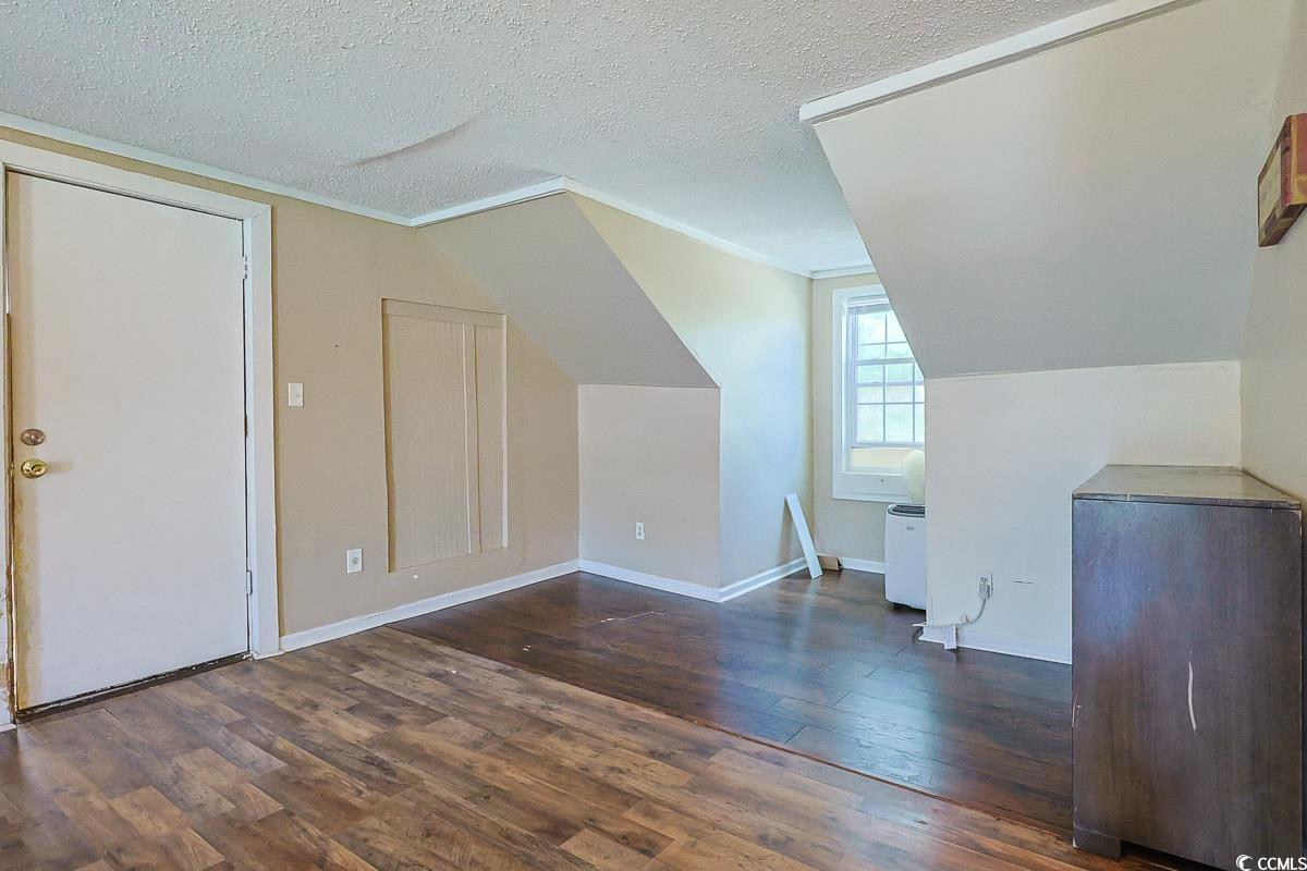 4300 Summit Trail Myrtle Beach, SC 29579 - Photo 29 of 39 Additional living space with dark wood-type flooring, a textured ceiling, and lofted ceiling