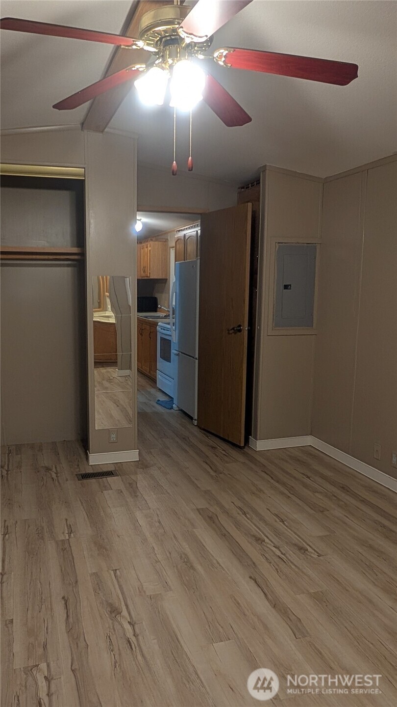 17340 Sargent Road Southwest, Unit 66 Rochester, WA 98579 - Photo 11 of 11 en empty room with wooden floor chandelier fan and windows