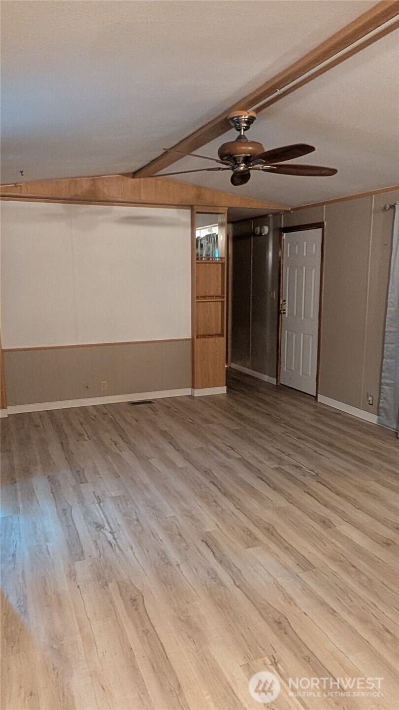 17340 Sargent Road Southwest, Unit 66 Rochester, WA 98579 - Photo 4 of 11 an empty room with wooden floor