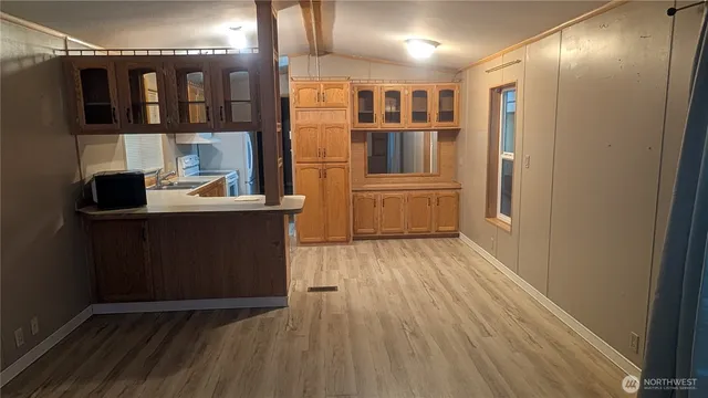 a kitchen with stainless steel appliances a refrigerator and a wooden floor