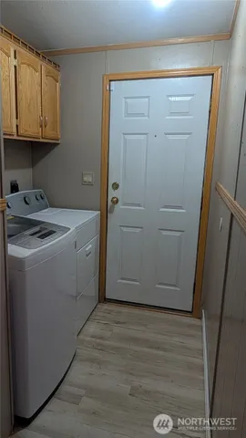 a utility room with wooden floor washer and dryer
