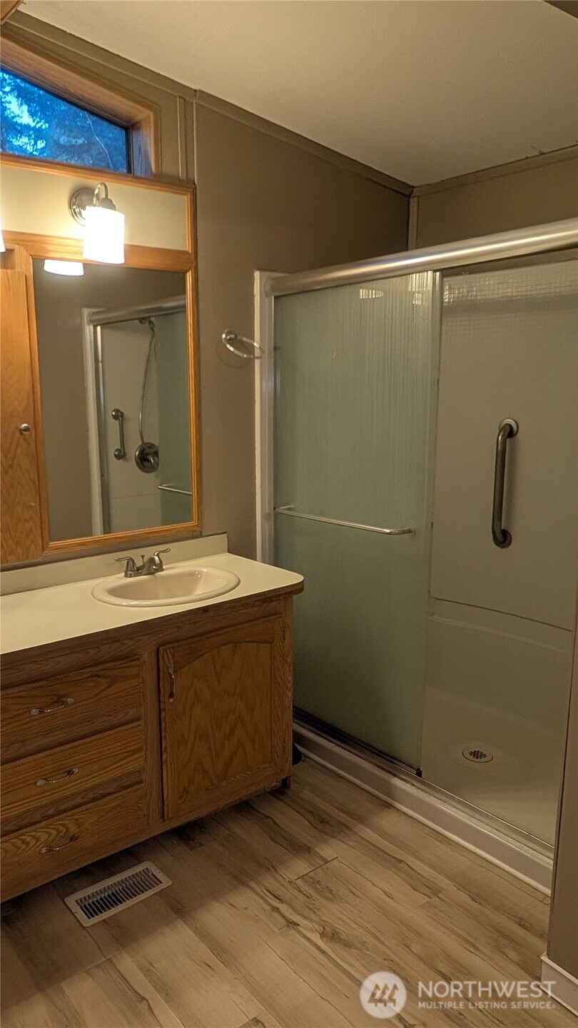 17340 Sargent Road Southwest, Unit 66 Rochester, WA 98579 - Photo 10 of 11 a bathroom with a double vanity sink and mirror