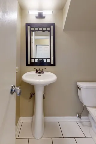 a bathroom with a sink toilet and mirror