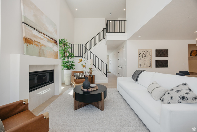 5902 Canyon Rim Road, Unit 620 Lehi, UT 84048 - Photo 21 of 78 Spacious living area featuring a two-story ceiling, contemporary fireplace with a sleek surround, and a double staircase with black railings