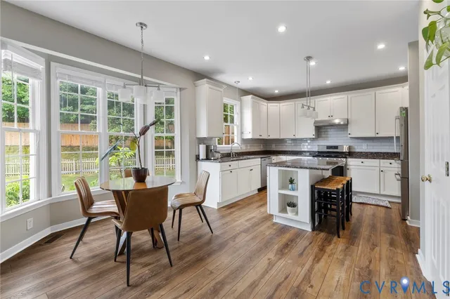 a kitchen with a table chairs refrigerator and cabinets