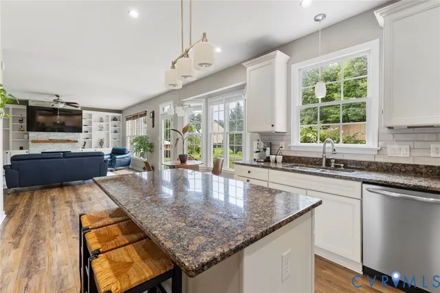 a kitchen with kitchen island granite countertop a stove and a sink