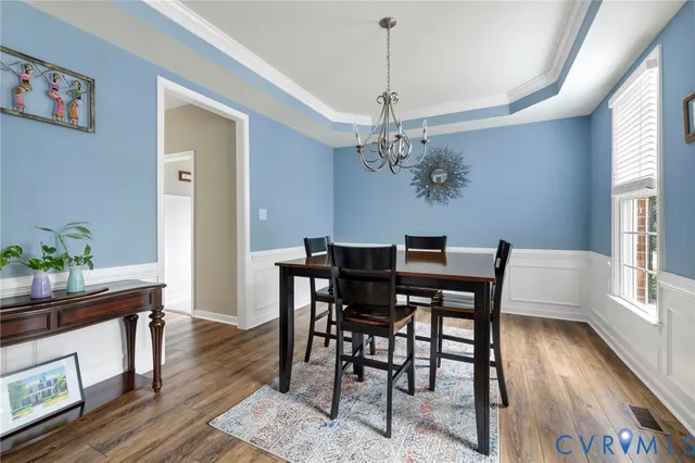 a view of a dining room with furniture wooden floor and a chandelier