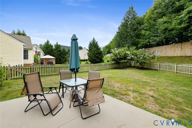 a view of a chairs and table in patio with a yard