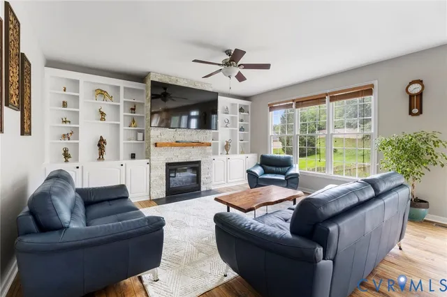 a living room with furniture a fireplace and a large window