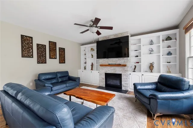 a living room with furniture a fireplace and a flat screen tv
