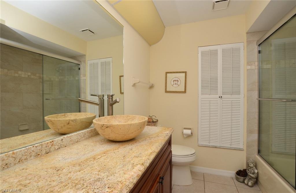 264 Henley Drive Naples, FL 34104 - Photo 19 of 25 a bathroom with a granite countertop sink a toilet and shower