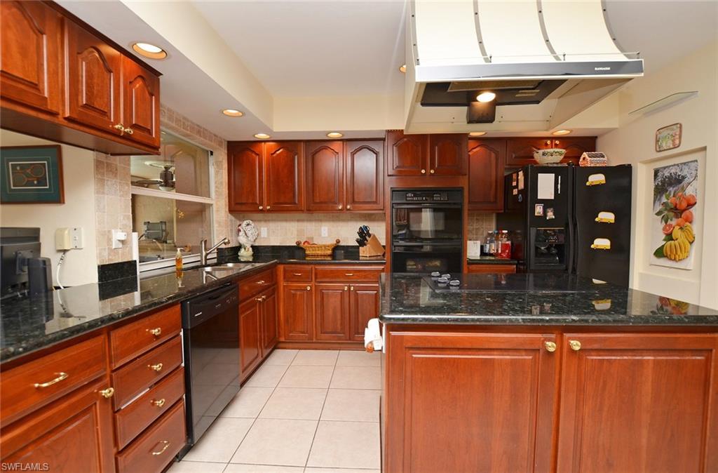 264 Henley Drive Naples, FL 34104 - Photo 3 of 25 a kitchen with stainless steel appliances granite countertop wooden cabinets a sink and dishwasher