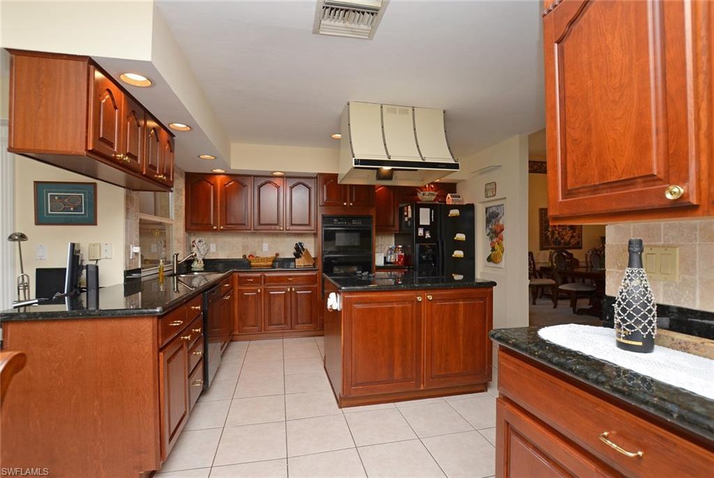 264 Henley Drive Naples, FL 34104 - Photo 4 of 25 a kitchen with stainless steel appliances granite countertop a sink and cabinets