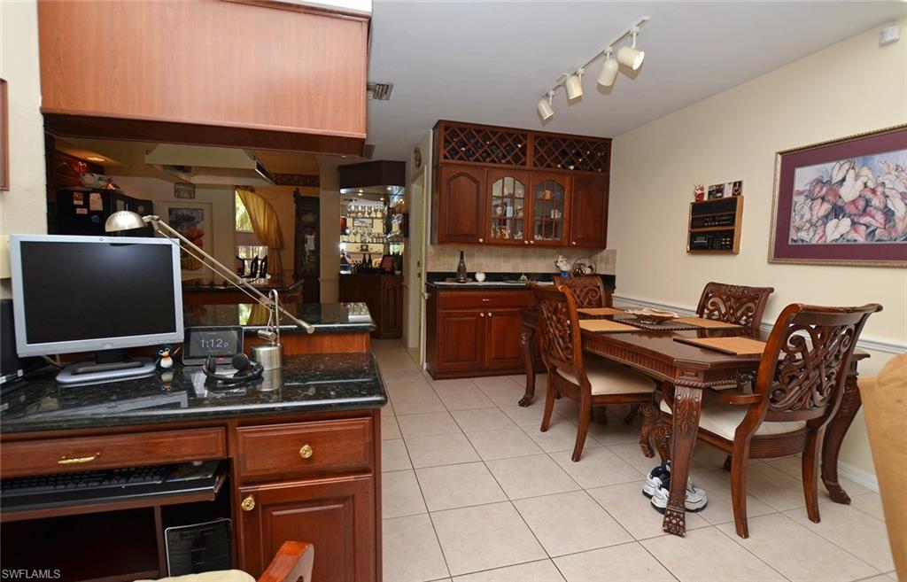 264 Henley Drive Naples, FL 34104 - Photo 5 of 25 a room with furniture a flat screen tv and kitchen view