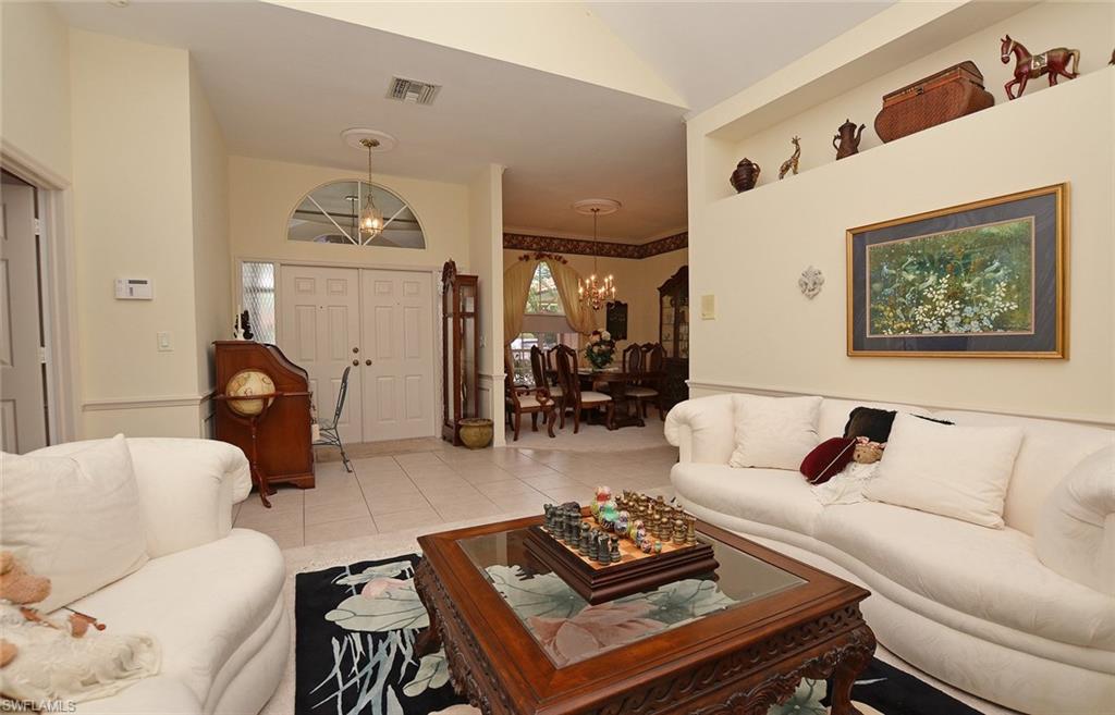 264 Henley Drive Naples, FL 34104 - Photo 8 of 25 a living room with furniture a rug and a fireplace