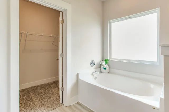 a white bath tub sitting next to a window