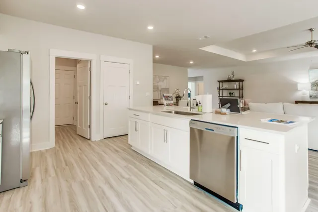 a kitchen with white cabinets and refrigerator