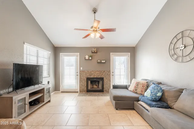 a living room with furniture a fireplace and a flat screen tv