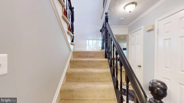 a view of staircase with railing and a chandelier