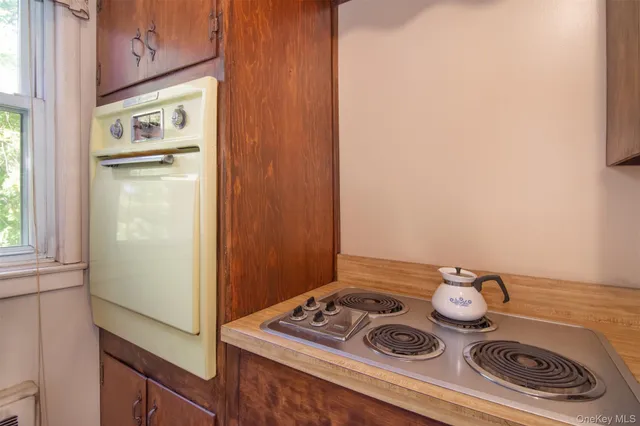 a white stove top oven sitting next to a window