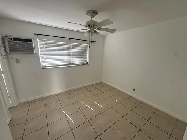 a view of a livingroom with a chandelier fan and wooden floor