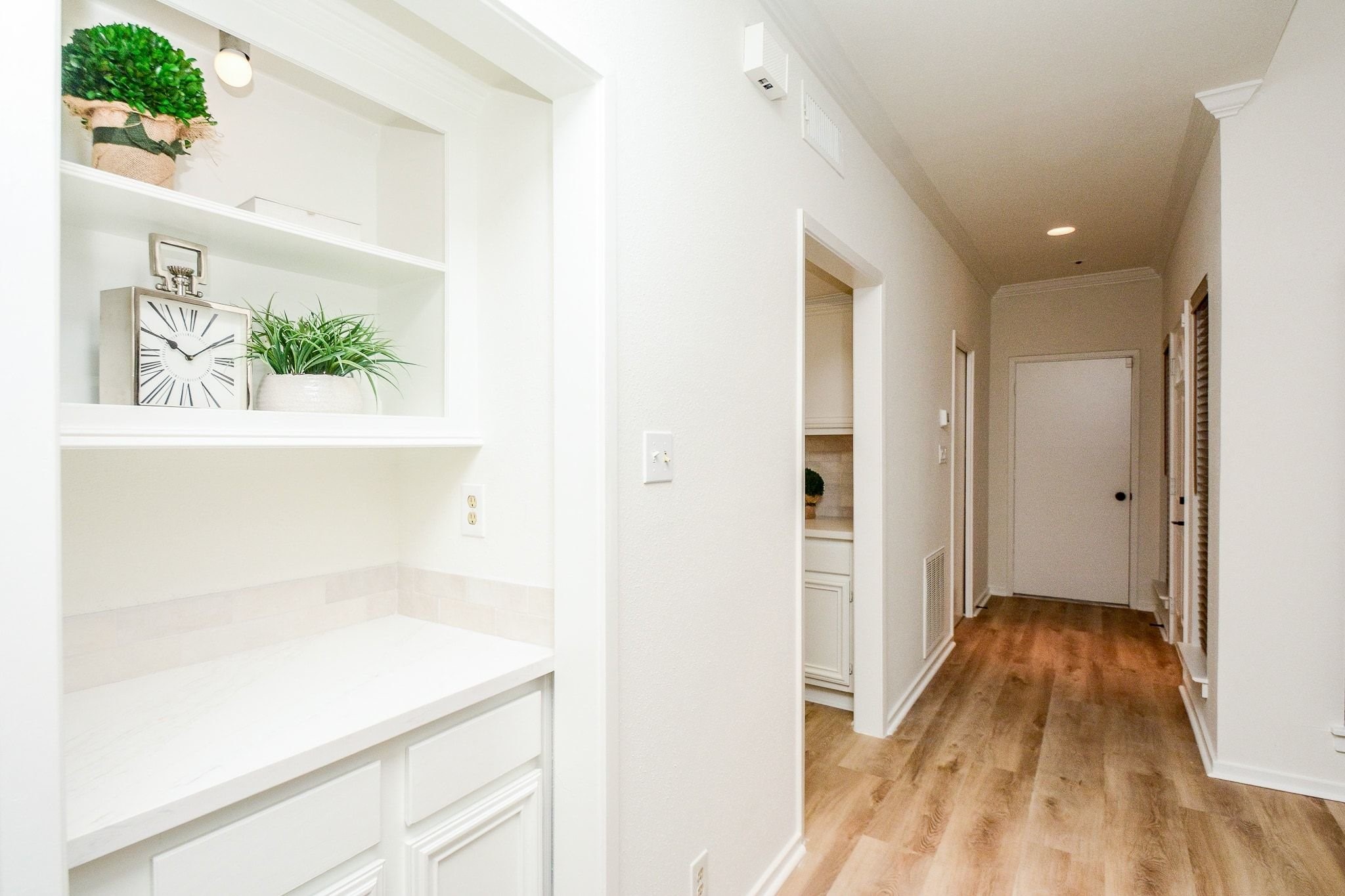820 Harold Street Houston, TX 77006 - Photo 13 of 33 A built-in shelving nook with cabinet storage adds a practical and polished touch to the hallway leading to the kitchen.